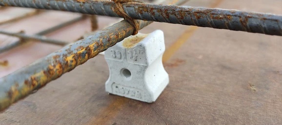 Concrete cover block supporting steel reinforcement bars in RCC slab construction